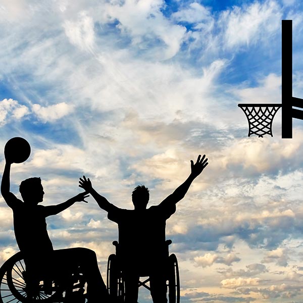 Image of two people playing basketball using their wheelchair